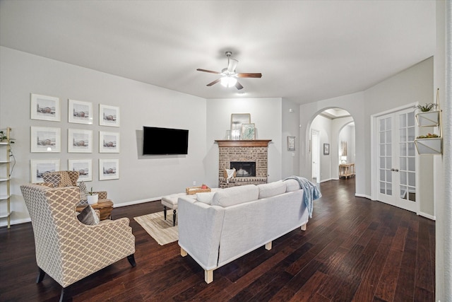 3030 Rabbit Brush Ln, Manvel, TX 77578 - living area with arched walkways, a ceiling fan, wood finished floors, french doors, and a fireplace