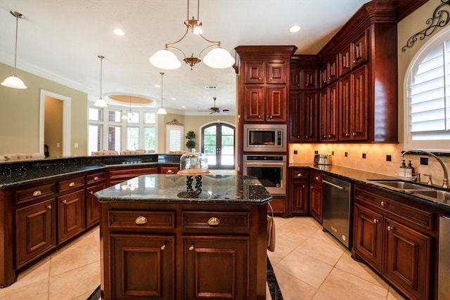 3610 Pembrooke Dr, Richmond, TX 77406 - kitchen with appliances with stainless steel finishes, dark brown cabinets, a kitchen island, light tile patterned floors, and crown molding