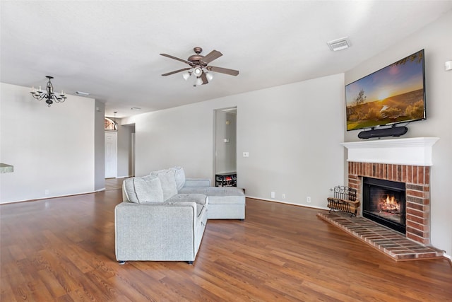 18618 Atascocita Forest Dr, Humble, TX 77346 - living room featuring a ceiling fan, wood finished floors, a brick fireplace, and a chandelier
