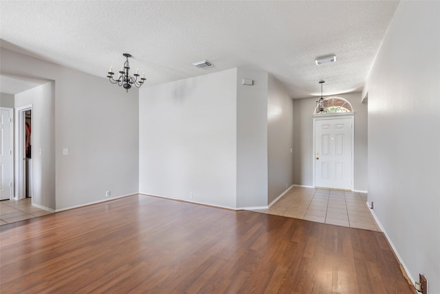 18618 Atascocita Forest Dr, Humble, TX 77346 - empty room featuring a chandelier, a textured ceiling, and wood finished floors
