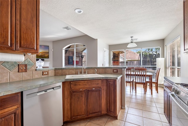 18618 Atascocita Forest Dr, Humble, TX 77346 - kitchen with stainless steel dishwasher, a peninsula, gas stove, backsplash, and light tile patterned flooring