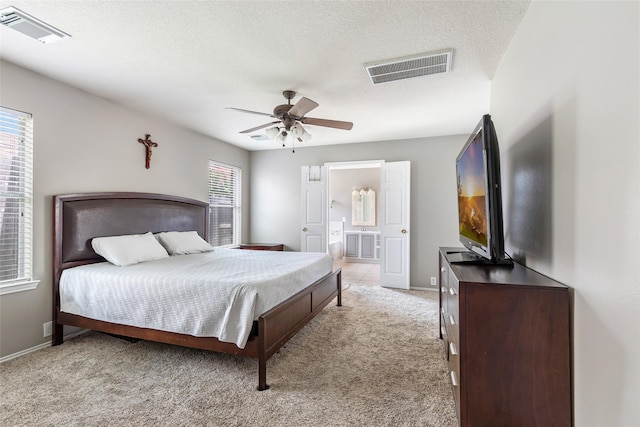 18618 Atascocita Forest Dr, Humble, TX 77346 - bedroom with light carpet, ensuite bathroom, a ceiling fan, and a textured ceiling