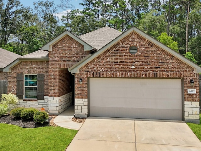 16129 Dockside St, Crosby, TX 77532 - view of front of house featuring a shingled roof, brick siding, a garage, concrete driveway, and stone siding