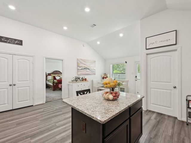 16129 Dockside St, Crosby, TX 77532 - kitchen with lofted ceiling, light wood-style floors, light stone counters, a kitchen island, and recessed lighting
