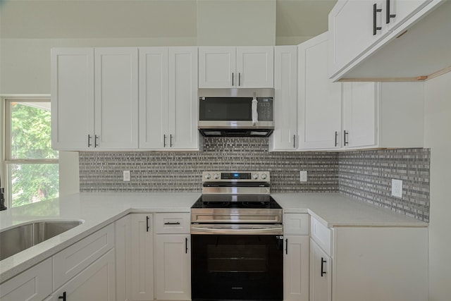 1909 Oregon St, Baytown, TX 77520 - kitchen featuring stainless steel appliances, light countertops, white cabinetry, and decorative backsplash