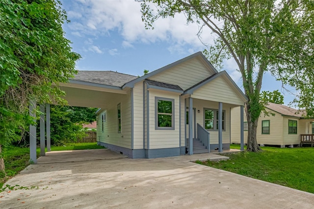 1909 Oregon St, Baytown, TX 77520 - bungalow with concrete driveway, entry steps, an attached carport, a front yard, and a shingled roof