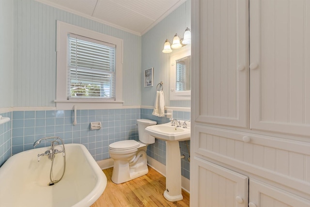 864 N Franklin St, La Grange, TX 78945 - bathroom featuring a freestanding bath, crown molding, wood finished floors, a wainscoted wall, and wallpapered walls