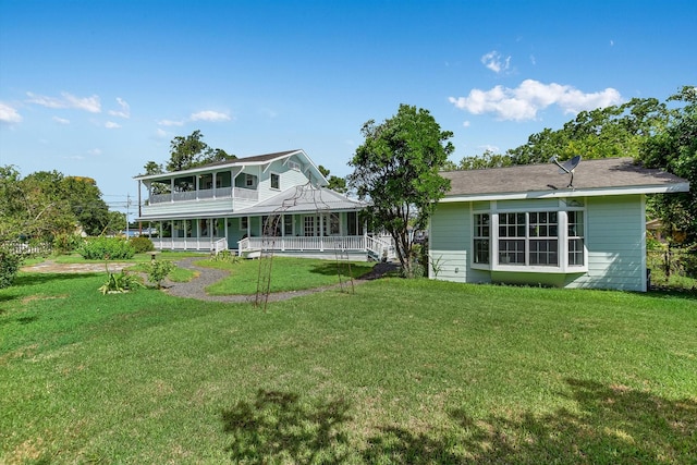 864 N Franklin St, La Grange, TX 78945 - rear view of house featuring covered porch, a lawn, and a balcony