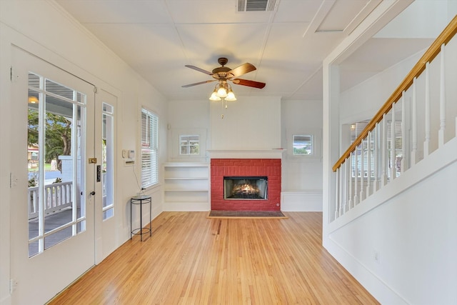 864 N Franklin St, La Grange, TX 78945 - living room featuring hardwood / wood-style floors, a brick fireplace, a ceiling fan, and stairs