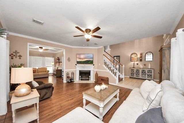 1503 Pine Ridge Ln, Pearland, TX 77581 - living area featuring a ceiling fan, a fireplace with raised hearth, wood finished floors, and crown molding