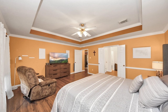 1503 Pine Ridge Ln, Pearland, TX 77581 - bedroom featuring a tray ceiling, wood finished floors, ornamental molding, and a ceiling fan