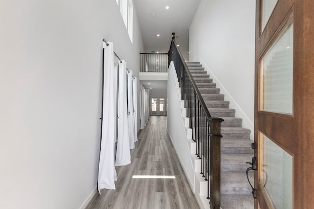 8722 Riverton Ridge Rd, Cypress, TX 77433 - hallway featuring a high ceiling, stairs, wood finished floors, and recessed lighting