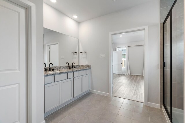8722 Riverton Ridge Rd, Cypress, TX 77433 - bathroom featuring double vanity, recessed lighting, tile patterned floors, and a tile shower
