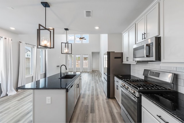 8722 Riverton Ridge Rd, Cypress, TX 77433 - kitchen with appliances with stainless steel finishes, light wood-style floors, tasteful backsplash, ceiling fan, and white cabinets
