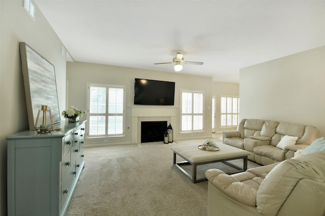 12911 Bristol Berry Dr, Cypress, TX 77429 - living area featuring a ceiling fan, plenty of natural light, light carpet, and a fireplace with flush hearth