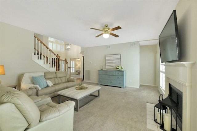 12911 Bristol Berry Dr, Cypress, TX 77429 - carpeted living room featuring a ceiling fan, plenty of natural light, stairs, and a fireplace
