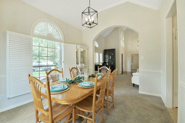 12911 Bristol Berry Dr, Cypress, TX 77429 - dining area with arched walkways, light colored carpet, ornamental molding, high vaulted ceiling, and a chandelier