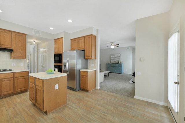 12911 Bristol Berry Dr, Cypress, TX 77429 - kitchen with black appliances, a ceiling fan, backsplash, light countertops, and under cabinet range hood