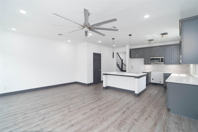 4417 Aledo St, Houston, TX 77051 - kitchen with stainless steel microwave, recessed lighting, a ceiling fan, light wood-style flooring, and open floor plan