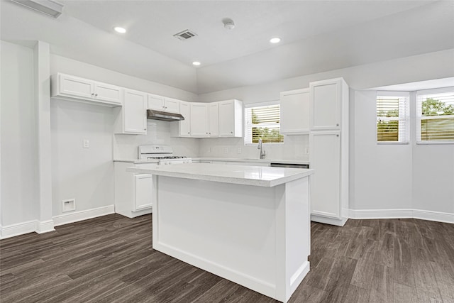 639 Ames St, Spring, TX 77373 - kitchen with under cabinet range hood, white stove, light countertops, a center island, and white cabinetry