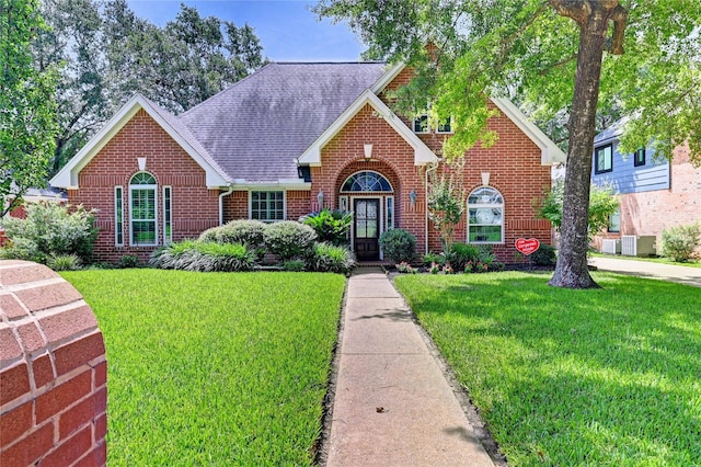 7611 Heathrow Ln, Spring, TX 77379 - traditional-style house featuring brick siding, a front yard, and roof with shingles