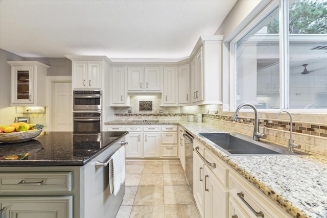 6019 Oak Creek Ln, Spring, TX 77379 - kitchen with double oven, tasteful backsplash, stone countertops, white cabinetry, and glass insert cabinets