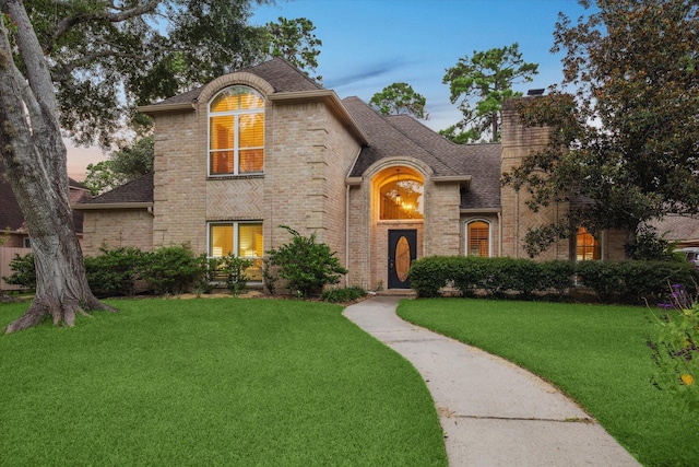 6019 Oak Creek Ln, Spring, TX 77379 - french provincial home featuring a shingled roof, brick siding, a front lawn, and a chimney