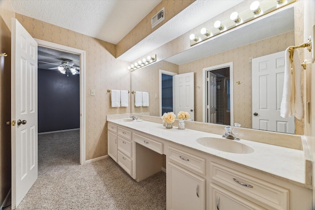 6019 Oak Creek Ln, Spring, TX 77379 - bathroom featuring double vanity, a textured ceiling, a ceiling fan, and wallpapered walls