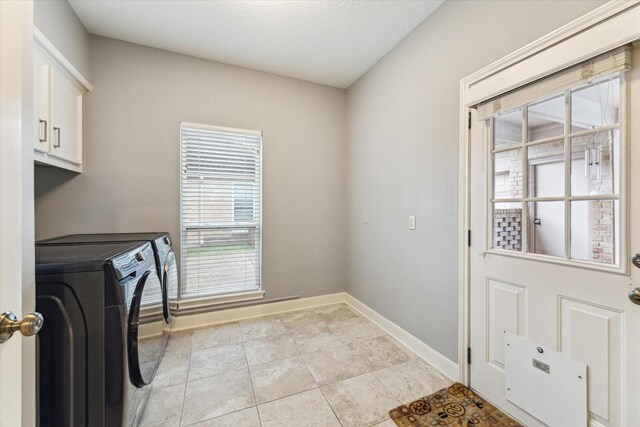 6019 Oak Creek Ln, Spring, TX 77379 - washroom with separate washer and dryer, cabinet space, and light tile patterned flooring