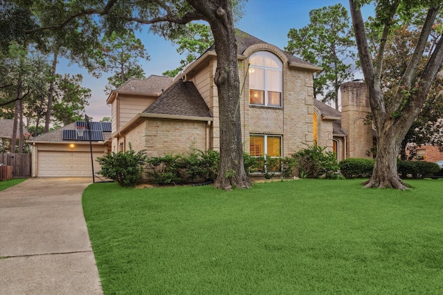 6019 Oak Creek Ln, Spring, TX 77379 - view of front facade featuring roof mounted solar panels, driveway, roof with shingles, an attached garage, and stone siding