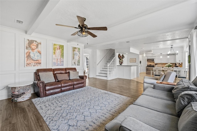19702 Sweet Forest Ln, Humble, TX 77346 - living room with a decorative wall, wood finished floors, ceiling fan, stairs, and a chandelier