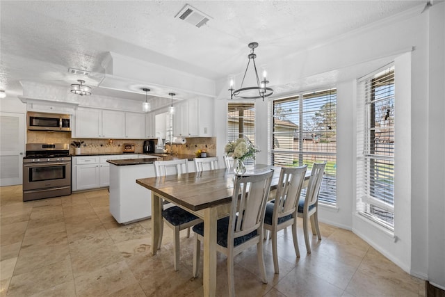 19702 Sweet Forest Ln, Humble, TX 77346 - dining room with a textured ceiling, a chandelier, ornamental molding, and light tile patterned floors