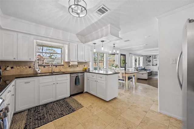 19702 Sweet Forest Ln, Humble, TX 77346 - kitchen featuring stainless steel appliances, tasteful backsplash, a peninsula, ornamental molding, and white cabinets