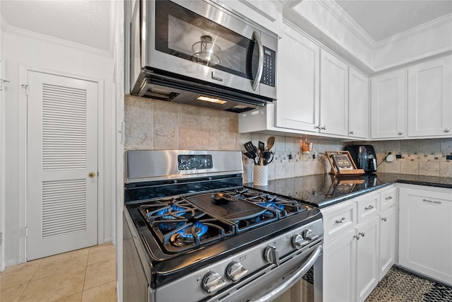 19702 Sweet Forest Ln, Humble, TX 77346 - kitchen featuring appliances with stainless steel finishes, ornamental molding, white cabinetry, dark stone countertops, and decorative backsplash