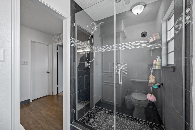 19702 Sweet Forest Ln, Humble, TX 77346 - full bath featuring a textured ceiling, a shower stall, and wood finished floors