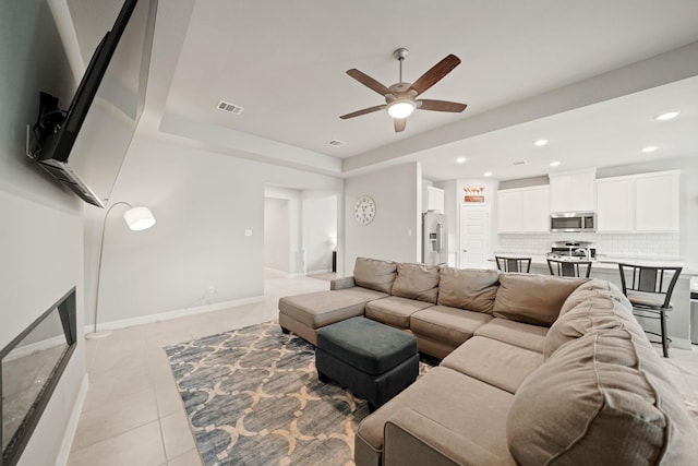 2849 Terrace Grove Dr, Conroe, TX 77304 - living area with ceiling fan, light tile patterned floors, recessed lighting, and a tray ceiling