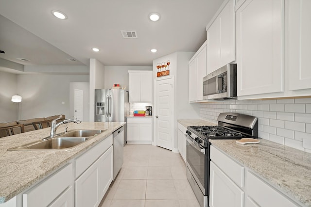 2849 Terrace Grove Dr, Conroe, TX 77304 - kitchen featuring stainless steel appliances, white cabinetry, recessed lighting, tasteful backsplash, and light tile patterned floors