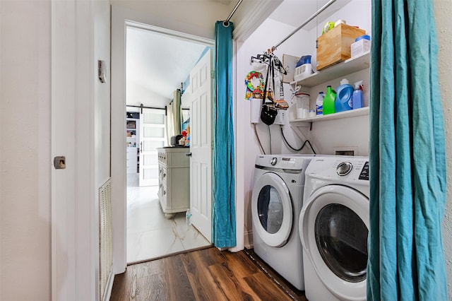 11906 Rowood Dr, Houston, TX 77070 - laundry room featuring washing machine and dryer, a barn door, and dark wood-style flooring