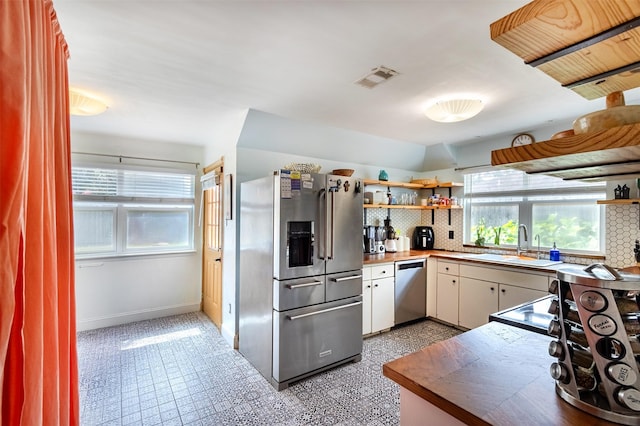 11906 Rowood Dr, Houston, TX 77070 - kitchen featuring stainless steel appliances, open shelves, and tasteful backsplash