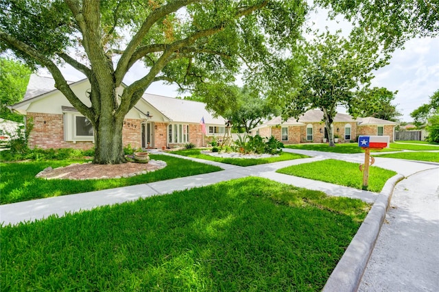 12327 Meadowhollow Dr, Meadows Place, TX 77477 - view of front of home featuring brick siding and a front yard