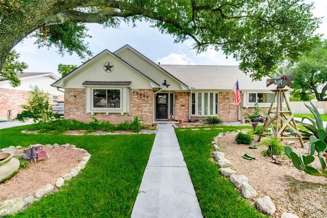 12327 Meadowhollow Dr, Meadows Place, TX 77477 - view of front of property featuring a front lawn, brick siding, and roof with shingles