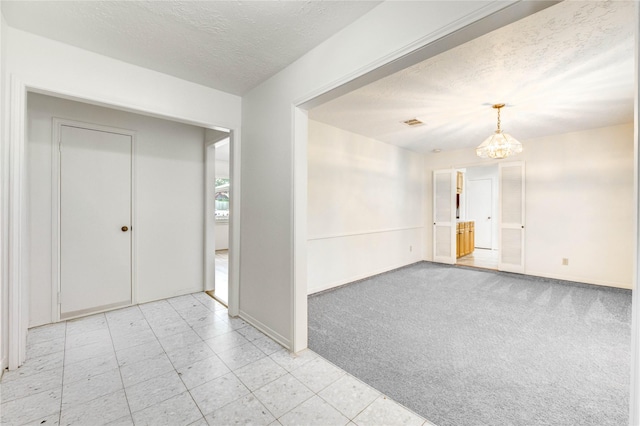 12327 Meadowhollow Dr, Meadows Place, TX 77477 - unfurnished room with a chandelier, a textured ceiling, and light carpet