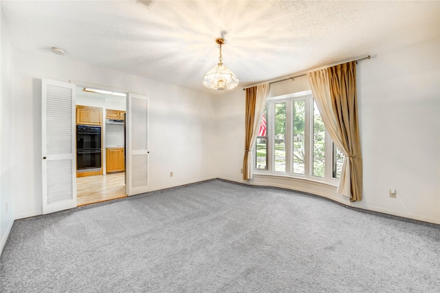12327 Meadowhollow Dr, Meadows Place, TX 77477 - unfurnished room with a chandelier, light carpet, and a textured ceiling