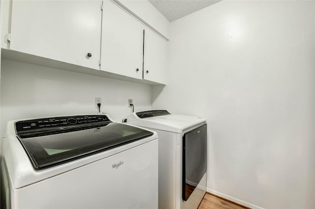 12327 Meadowhollow Dr, Meadows Place, TX 77477 - washroom featuring cabinet space, washing machine and dryer, and light wood-style floors