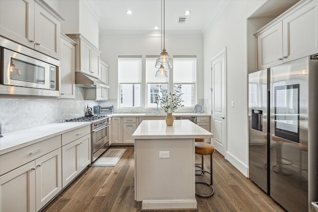 8764 Park Kolbe Ln, Houston, TX 77080 - kitchen with appliances with stainless steel finishes, ornamental molding, decorative backsplash, dark wood-type flooring, and a kitchen bar