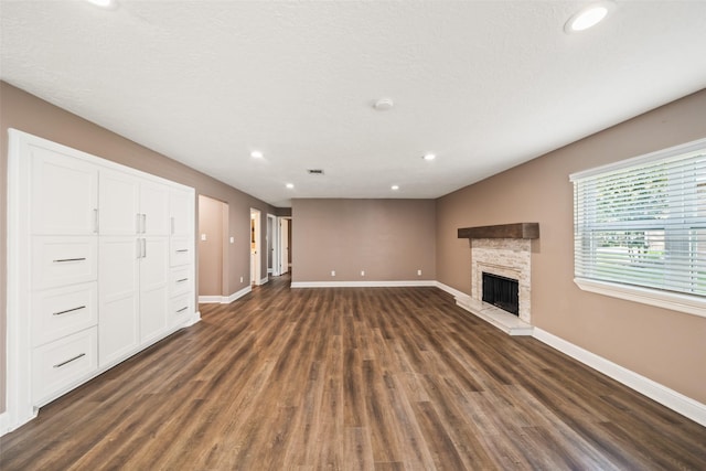 3019 Ramblewood Rd, Montgomery, TX 77356 - unfurnished living room featuring recessed lighting, dark wood-style floors, and a stone fireplace