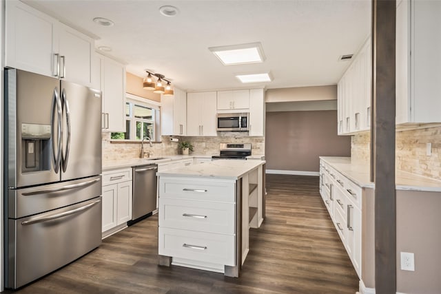 3019 Ramblewood Rd, Montgomery, TX 77356 - kitchen featuring stainless steel appliances, white cabinetry, dark wood-type flooring, light stone counters, and backsplash
