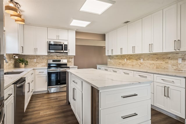 3019 Ramblewood Rd, Montgomery, TX 77356 - kitchen featuring appliances with stainless steel finishes, tasteful backsplash, a kitchen island, and dark wood-style flooring