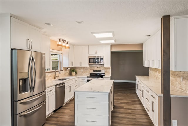 3019 Ramblewood Rd, Montgomery, TX 77356 - kitchen featuring appliances with stainless steel finishes, dark wood-type flooring, white cabinetry, and tasteful backsplash