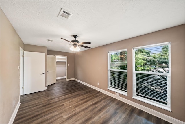 3019 Ramblewood Rd, Montgomery, TX 77356 - unfurnished bedroom featuring dark wood-style floors, a textured ceiling, and a ceiling fan